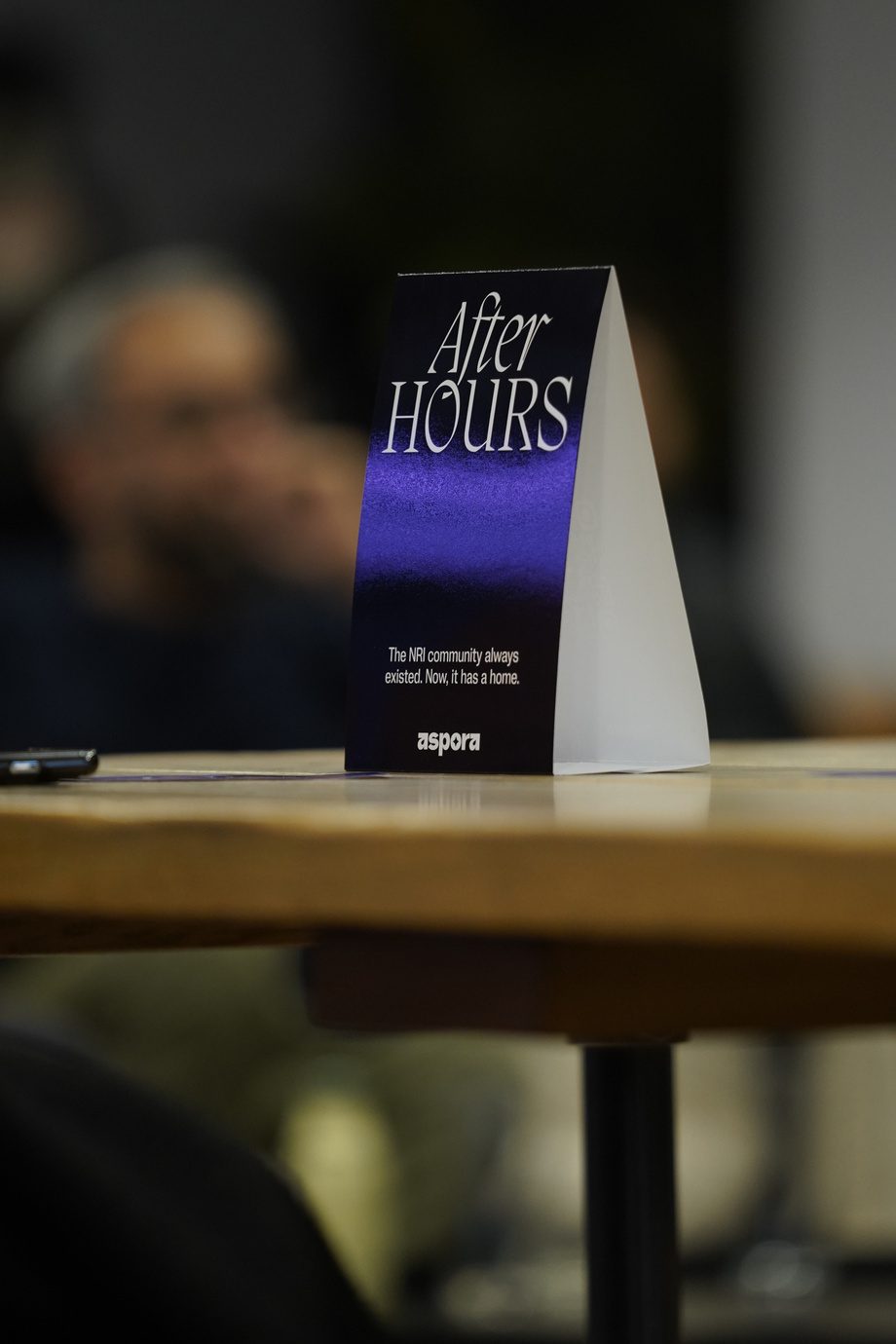 A branded tent card on a table at the Aspora event