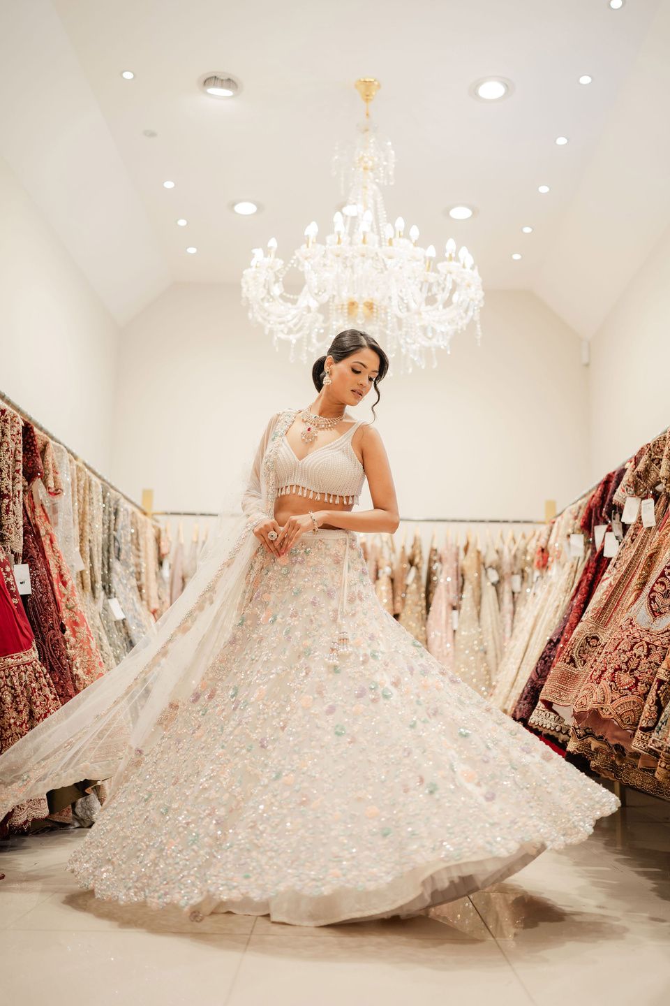 A bride in an ivory lehenga among the racks at Malabar Gold & Diamonds