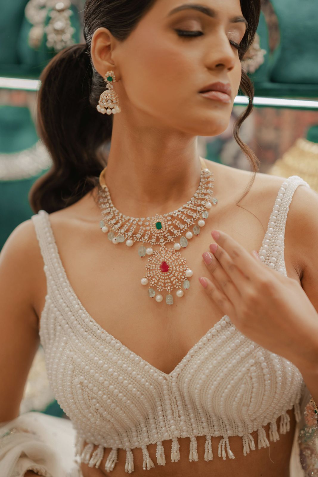 Model wearing a diamond and emerald necklace